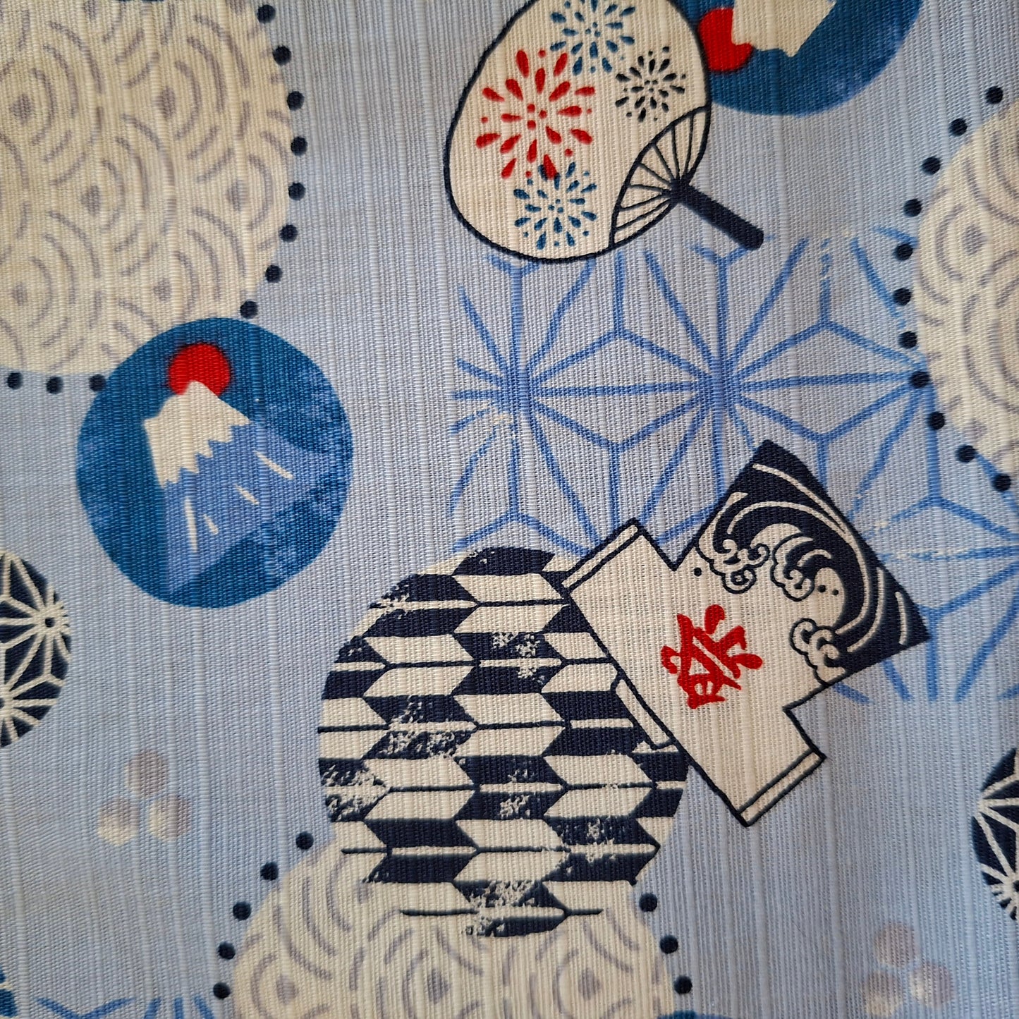 Traditional Japanese pattern with geometric shapes and a character holding a fan on a blue background.