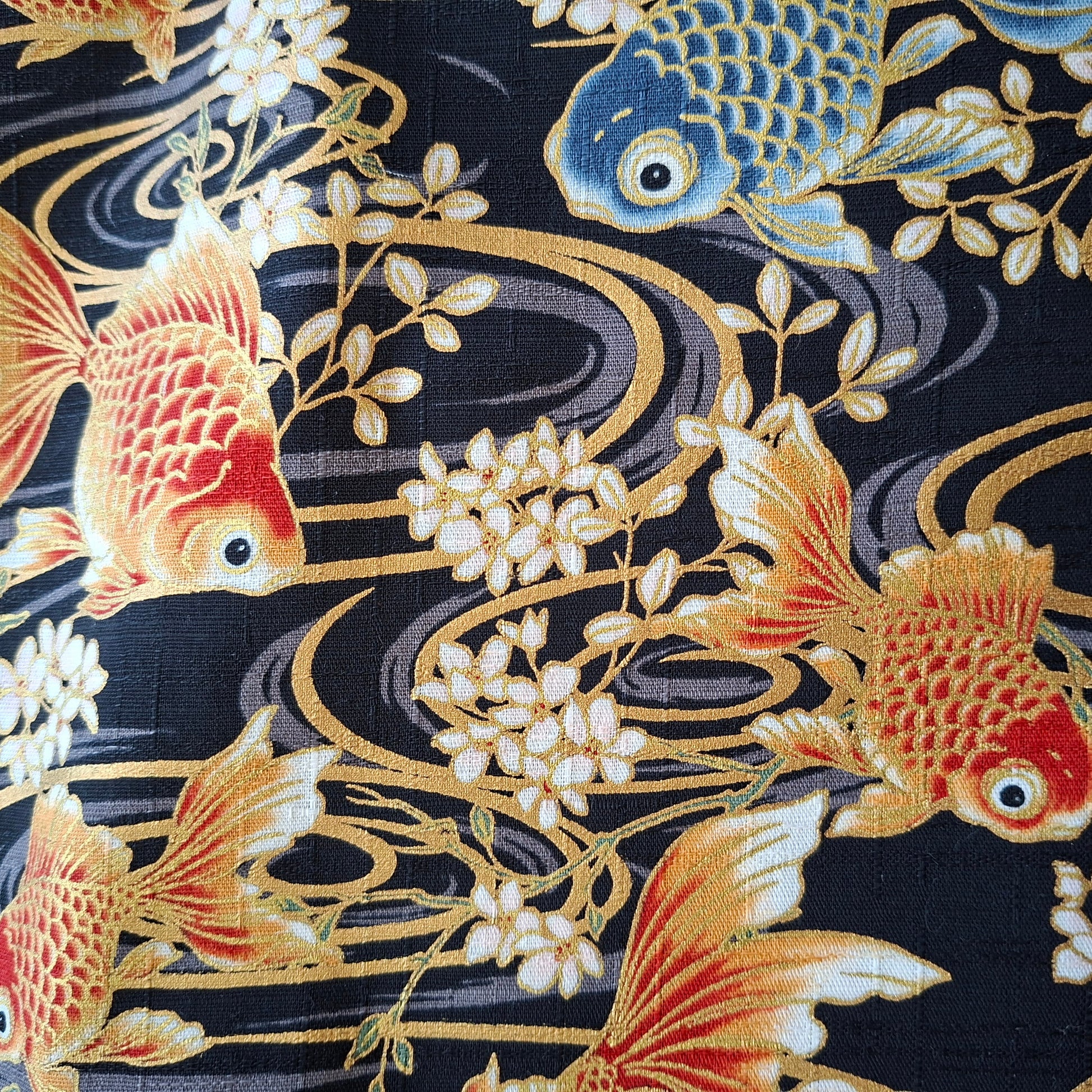 Patterned fabric with goldfish and floral designs on a dark background