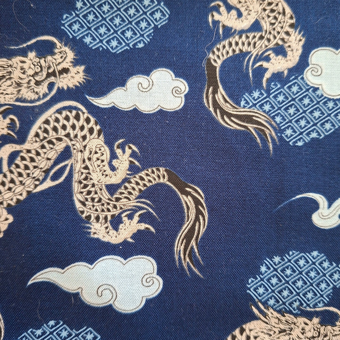 Fabric with gold dragons and geometric patterns on a blue background